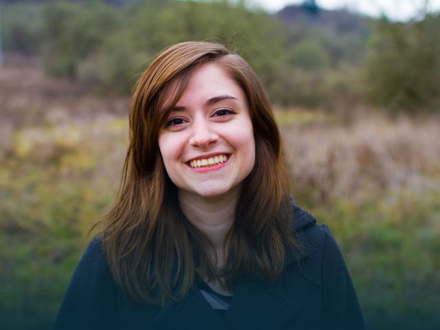 Jente med brunt hår som smiler